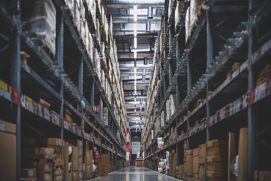 A long aisle between loaded warehouse racking